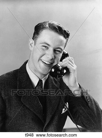 Stock Photo - 1940 1940S 1950 1950S Young Man Talking On Telephone. Fotosearch