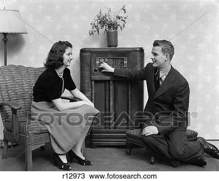 Stock Image - 1940 1940S Boy And Girl Sitting In Living Room Listening To Radio . Fotosearch