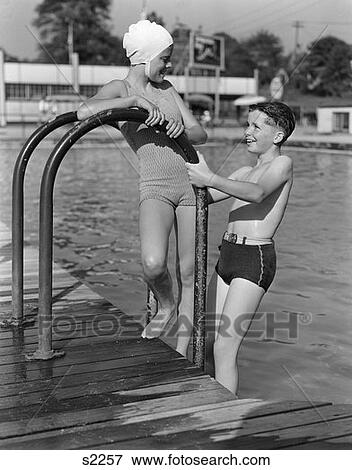 Stock Photo - 1940 1940S Girl And Boy Standing In Pool Wearing Bathing Suits . Fotosearch
