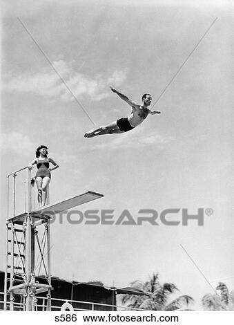 1940 1940S Man Jumping Off Diving Board Woman Watching View Large Photo Image Stock Photograph - 1940 1940S Man Jumping Off Diving Board Woman Watching . Fotosearch
