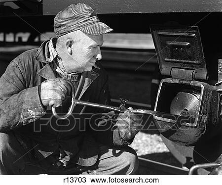 Stock Image - 1940 1940S Rail Engineer Lineman Turning Long Key Gear Box Railroad Car Lock Unlock Work Working Train Man Men Occupation Retro. Fotosearch