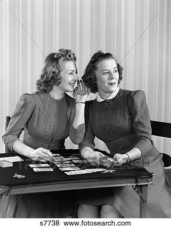 1940 1940S Two Girls Sitting At Card Table Playing Cards And Whispering View Large Photo Image Stock Photo - 1940 1940S Two Girls Sitting At Card Table Playing Cards And Whispering . Fotosearch