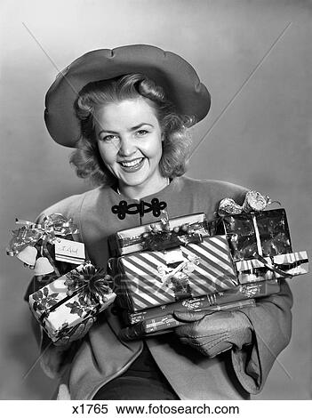Stock Photography - 1940 1940S Woman In Hat Holding Wrapped Presents Smiling . Fotosearch