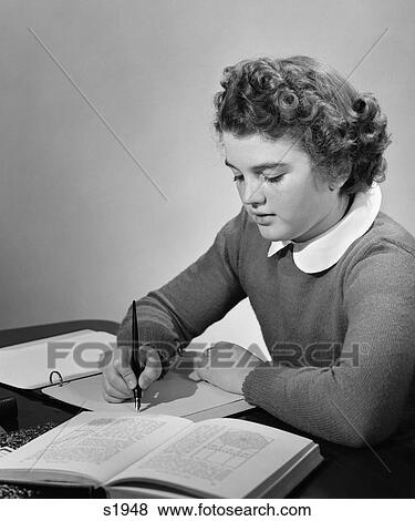 Stock Photo - 1940 1940S Young Girl In School Uniform Stydying At Desk With Books And Notes . Fotosearch