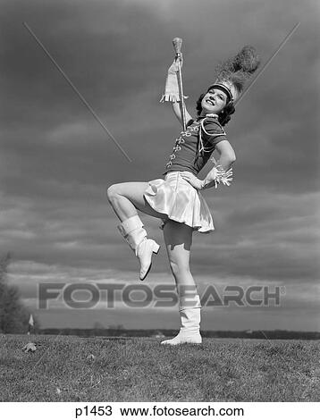 1940s 女 中に バトンガール 楽隊長 バンド ユニフォーム バトン 縁どられた 手袋 帽子 羽 Plume ブーツ 短いスカート １本の脚 持ち上げられる ストックイメージ P1453 Fotosearch