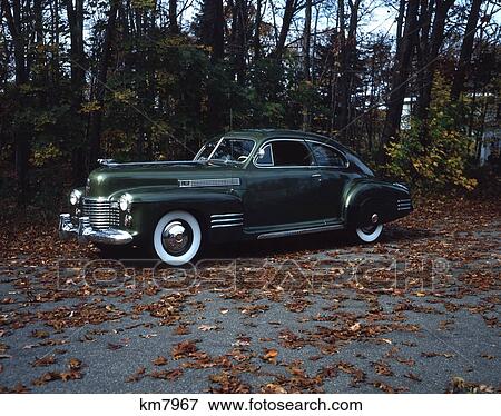1940S 1941 Cadillac Model 61 Coupe Green Antique Car On Road Covered With Autumn Leaves White Side Wall Tires View Large Photo Image Stock Photo - 1940S 1941 Cadillac Model 61 Coupe Green Antique Car On Road Covered With Autumn Leaves White Side Wall Tires. Fotosearch