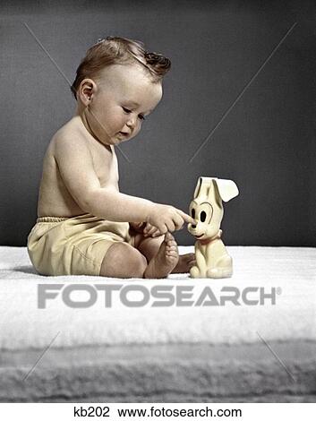 1940S 1950S Baby Sitting Touching Toy Dog View Large Photo Image Stock Image - 1940S 1950S Baby Sitting Touching Toy Dog. Fotosearch