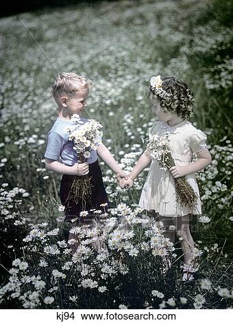 1940S 1950S Boy Girl Picking Daisies In Field Of Flowers Summer Sprin View Large Photo Image Picture - 1940S 1950S Boy Girl Picking Daisies In Field Of Flowers Summer Sprin . Fotosearch