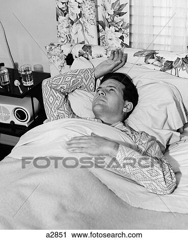 1940S 1950S Sick Man In Bed In Pajamas One Hand On Chest One Above His Head On Pillow View Large Photo Image Stock Image - 1940S 1950S Sick Man In Bed In Pajamas One Hand On Chest One Above His Head On Pillow. Fotosearch