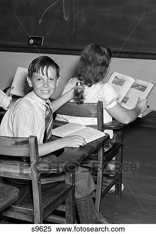 1940S 3 Kids Students Classroom Boys Girl From Back One Boy Turned Smiling At Camera Mischief Open Books Desks View Large Photo Image Stock Photography - 1940S 3 Kids Students Classroom Boys Girl From Back One Boy Turned Smiling At Camera Mischief Open Books Desks . Fotosearch