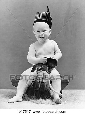 Stock Photo - 1940S Baby Seated On Stool Wearing Scottish Costume Reaching Into Change Purse . Fotosearch