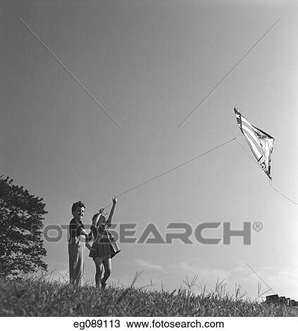 1940S Boy And Girl On Hillside Flying Kite View Large Photo Image Stock Image - 1940S Boy And Girl On Hillside Flying Kite. Fotosearch