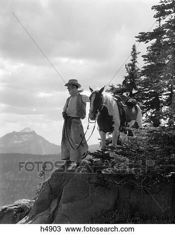 1940S Cowboy In Chaps Vest Hat & Kerchief With Palomino Horse On Peak Overlooking Glacier Park View Large Photo Image Stock Image - 1940S Cowboy In Chaps Vest Hat & Kerchief With Palomino Horse On Peak Overlooking Glacier Park . Fotosearch