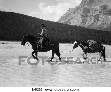 1940S Cowboy On Horseback Crossing River With 2Nd Horse In Tow View Large Photo Image Stock Photography - 1940S Cowboy On Horseback Crossing River With 2Nd Horse In Tow . Fotosearch