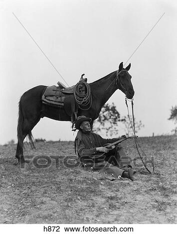 1940S Cowboy Sitting Against Horse'S Leg Strumming Guitar & Whistling View Large Photo Image Stock Image - 1940S Cowboy Sitting Against Horse'S Leg Strumming Guitar & Whistling . Fotosearch