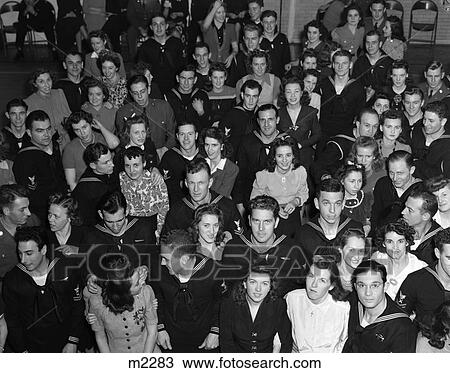 Stock Image - 1940S Crowd Men Women Civilians Soldiers Sailors Looking Up Smiling At Camera Uso Center . Fotosearch