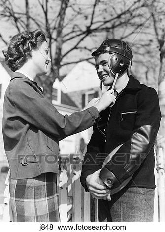 1940S Cute Romantic Teen Couple Girl Holding Straps Of Boys Football Helmet View Large Photo Image Stock Photo - 1940S Cute Romantic Teen Couple Girl Holding Straps Of Boys Football Helmet. Fotosearch