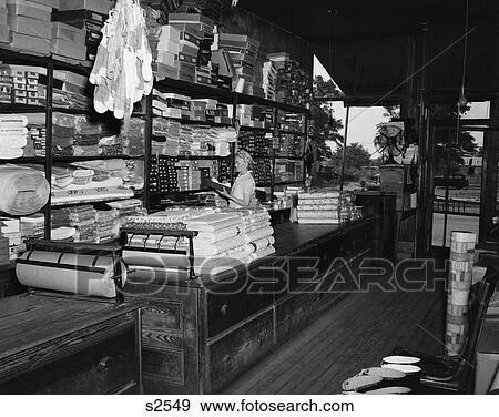 1940S Elderly Woman Pulling Merchandise From Shelf In Country Store View Large Photo Image Stock Photo - 1940S Elderly Woman Pulling Merchandise From Shelf In Country Store . Fotosearch