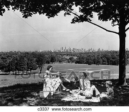 Stock Photo - 1940S Family Picnicking Under A Tree In Fairmont Park With Skyline Of Philadelphia Pa On Horizon. Fotosearch