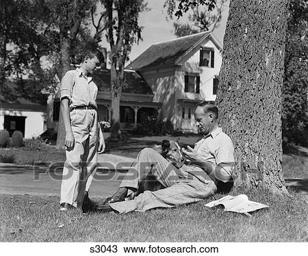 1940S Father And Dog Sitting Under Tree Teenage Son Standing Front Yard Houses Street Community View Large Photo Image Stock Image - 1940S Father And Dog Sitting Under Tree Teenage Son Standing Front Yard Houses Street Community . Fotosearch