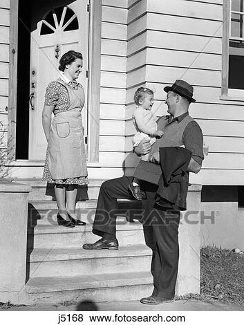 Stock Photo - 1940S Father On Steps Holding Daughter With Mother Watching . Fotosearch