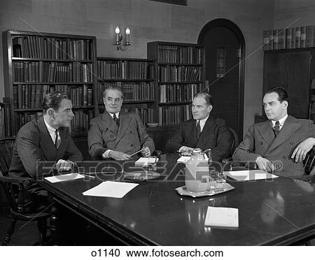 1940S Group Four Businessmen Corporate Executives Sit Around Conference Table Serious Expressions Meeting Decision Papers View Large Photo Image Stock Image - 1940S Group Four Businessmen Corporate Executives Sit Around Conference Table Serious Expressions Meeting Decision Papers. Fotosearch