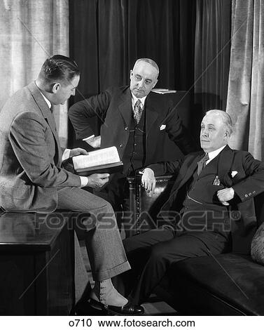 1940S Group Of Three Businessmen Gathered Around Having Discussion One Referring To Book View Large Photo Image Stock Image - 1940S Group Of Three Businessmen Gathered Around Having Discussion One Referring To Book . Fotosearch
