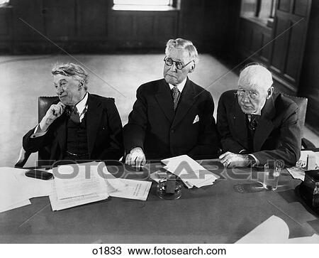 1940S Group Of Three Elderly Businessmen Sitting At Conference Table With Attention Directed To Speaker Not Shown View Large Photo Image Stock Image - 1940S Group Of Three Elderly Businessmen Sitting At Conference Table With Attention Directed To Speaker Not Shown . Fotosearch