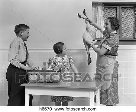 1940S Housewife Showing Raw Fresh Plucked Turkey To Son And Daughter In Kitchen View Large Photo Image Stock Image - 1940S Housewife Showing Raw Fresh Plucked Turkey To Son And Daughter In Kitchen . Fotosearch