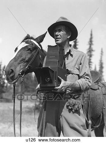 1940S Man In Fedora & Jodphurs Standing Next To Saddled Horse Holding Graflex Camera View Large Photo Image Stock Photograph - 1940S Man In Fedora & Jodphurs Standing Next To Saddled Horse Holding Graflex Camera . Fotosearch