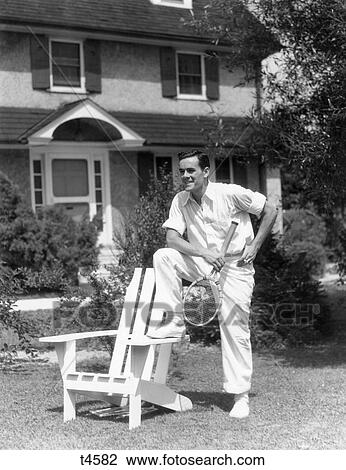 1940S Man In Tennis Whites Holding Racket With Foot On White Adirondack Chair On Lawn View Large Photo Image Stock Image - 1940S Man In Tennis Whites Holding Racket With Foot On White Adirondack Chair On Lawn. Fotosearch