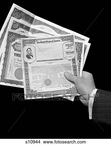 1940S Mans Hand Holding 4 Stocks Bonds Certificates Documents Value 1000 Dollars Finance Stock Savings Bond Banking Wealth View Large Photo Image Picture - 1940S Mans Hand Holding 4 Stocks Bonds Certificates Documents Value 1000 Dollars Finance Stock Savings Bond Banking Wealth. Fotosearch