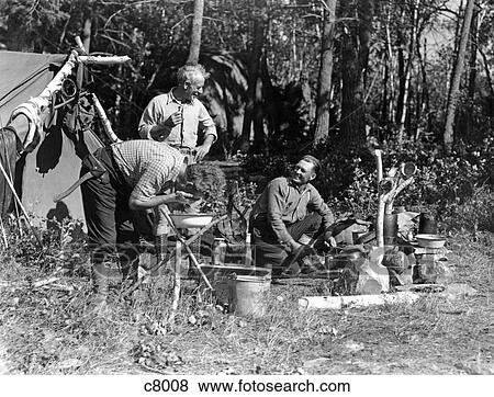 1940S Men At Campsite One Washing His Face At Tripod Stand The Other Tending Campfire Canada Lake Of The Woods Ontario View Large Photo Image Stock Photo - 1940S Men At Campsite One Washing His Face At Tripod Stand The Other Tending Campfire Canada Lake Of The Woods Ontario. Fotosearch