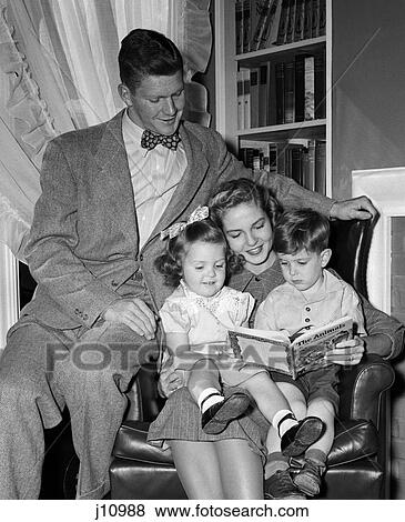 Stock Photo - 1940S Mother In Armchair Reading To Son & Daughter With Father Looking On . Fotosearch