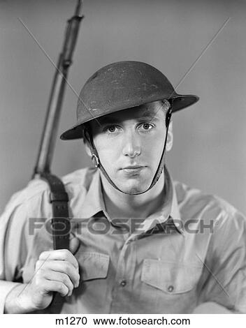 1940S Portrait Of American Man Soldier Serious Expression Gun Rifle On Shoulder Helmet With Chin Strap Ww2 Army Vintage View Large Photo Image Stock Image - 1940S Portrait Of American Man Soldier Serious Expression Gun Rifle On Shoulder Helmet With Chin Strap Ww2 Army Vintage . Fotosearch