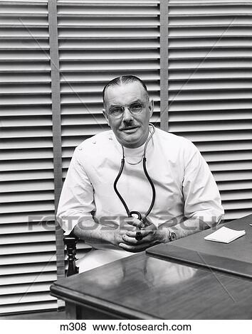 1940S Portrait Of Doctor Sitting Behind Desk Smiling View Large Photo Image Stock Photo - 1940S Portrait Of Doctor Sitting Behind Desk Smiling . Fotosearch