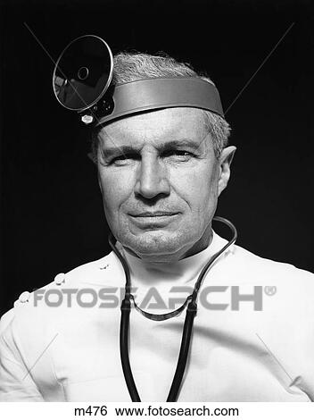 Stock Photograph - 1940S Portrait Of Senior Doctor Wearing Opthalmoscope And Stethoscope . Fotosearch