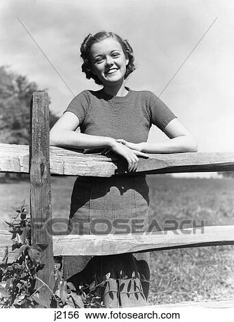 1940S Portrait Smiling Young Girl Woman Leaning On Wooden Fence View Large Photo Image Stock Photograph - 1940S Portrait Smiling Young Girl Woman Leaning On Wooden Fence. Fotosearch