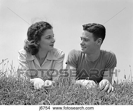 1940S Portrait Teen Couple Man Woman Boy Girl Lying In Grass Looking At One Another View Large Photo Image Picture - 1940S Portrait Teen Couple Man Woman Boy Girl Lying In Grass Looking At One Another . Fotosearch