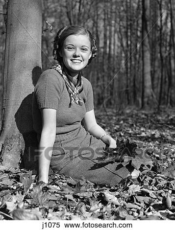 Stock Photography - 1940S Pretty Smiling Teen Young Woman Girl Sitting Under Tree In Autumn Leaves Portrait . Fotosearch
