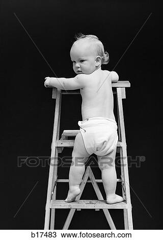 Stock Image - 1940S Rear View Of Baby Climbing Ladder Turning Head Back Toward Camera . Fotosearch