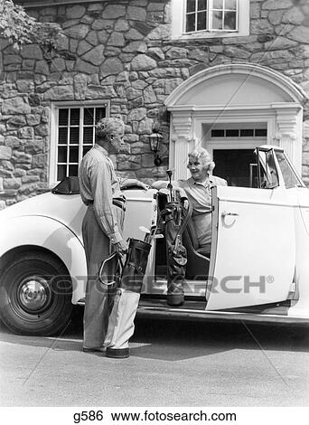 1940S Senior Retired Couple Loading Golf Clubs Into White Convertible Car In Front Stone House View Large Photo Image Stock Photograph - 1940S Senior Retired Couple Loading Golf Clubs Into White Convertible Car In Front Stone House . Fotosearch