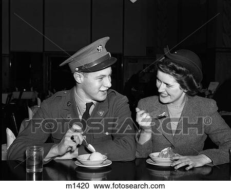 1940S Smiling Couple Woman Man Soldier In Uniform Sitting At Soda Fountain Counter Eating Dish Of Ice Cream View Large Photo Image Stock Image - 1940S Smiling Couple Woman Man Soldier In Uniform Sitting At Soda Fountain Counter Eating Dish Of Ice Cream . Fotosearch
