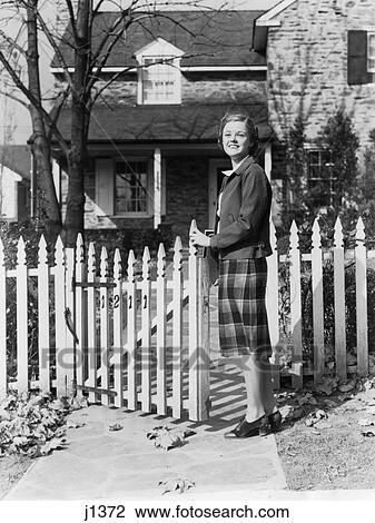1940S Smiling Pretty Young Teen Girl Standing By White Picket Fence In Front Of Stone House Autumn View Large Photo Image Stock Image - 1940S Smiling Pretty Young Teen Girl Standing By White Picket Fence In Front Of Stone House Autumn. Fotosearch