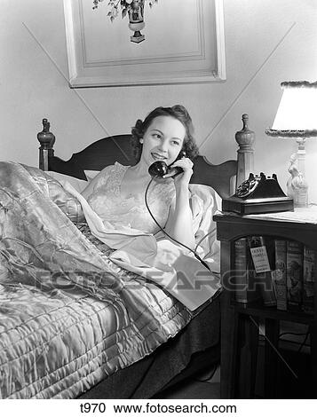 1940S Smiling Woman In Bed Answering Phone On Night Stand With Lamp Quilted Bedspread Late Wake Up View Large Photo Image Stock Image - 1940S Smiling Woman In Bed Answering Phone On Night Stand With Lamp Quilted Bedspread Late Wake Up . Fotosearch