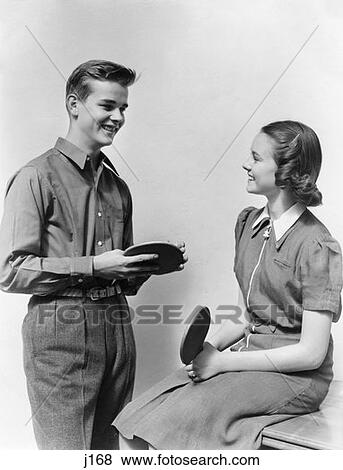 1940S Teen Couple Boy Girl Talking Smiling Holding Ping Pong Table Tennis Paddles View Large Photo Image Stock Photo - 1940S Teen Couple Boy Girl Talking Smiling Holding Ping Pong Table Tennis Paddles. Fotosearch