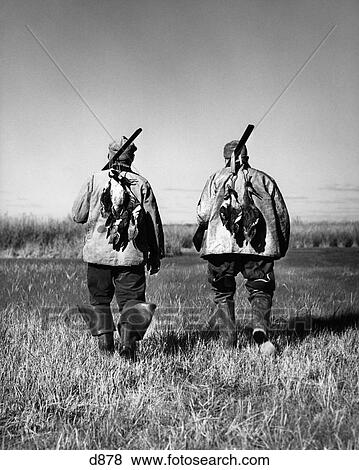 Stock Photo - 1940S Two Men Back View Walking Field Duck Hunting Sport . Fotosearch