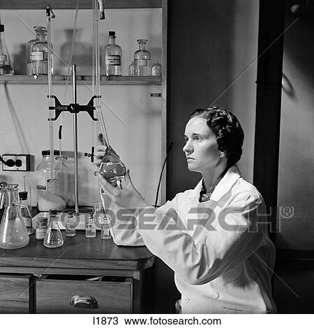 1940S Woman In Lab Coat Holding Up & Examining Beaker Of Liquid View Large Photo Image Stock Image - 1940S Woman In Lab Coat Holding Up & Examining Beaker Of Liquid . Fotosearch