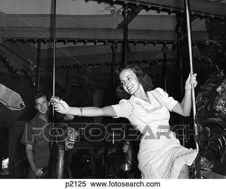 1940S Woman On Carousel Reaching For Brass Ring Man In Background Indoor View Large Photo Image Stock Photography - 1940S Woman On Carousel Reaching For Brass Ring Man In Background Indoor . Fotosearch