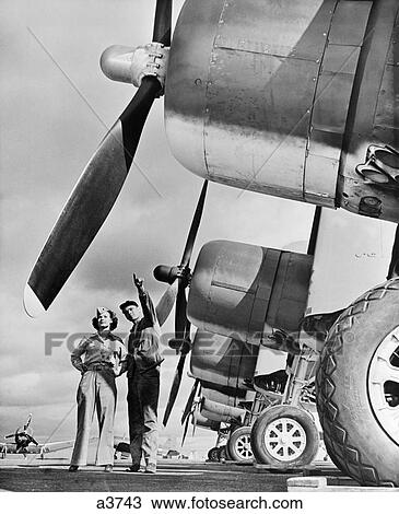 1940S Wwii Marine Corp Technician With Woman Reservist Inspecting Fighter Aircraft On The Air Field View Large Photo Image Stock Image - 1940S Wwii Marine Corp Technician With Woman Reservist Inspecting Fighter Aircraft On The Air Field . Fotosearch